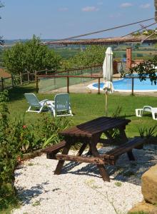 a picnic table and two chairs next to a pool at La Pietraia in Panicale