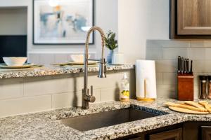 a kitchen counter with a sink in a kitchen at Upscale City Apartment with Pool , Fitness Center in Carrollton