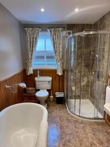 a bathroom with a shower and a toilet and a tub at The Nairn House in Nairn