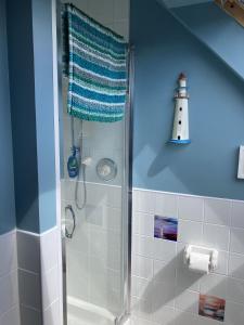 a bathroom with a shower with a lighthouse on the wall at The Nairn House in Nairn +19 photos