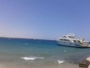a boat docked in the water next to a beach at Desert Rose Apartment in Hurghada
