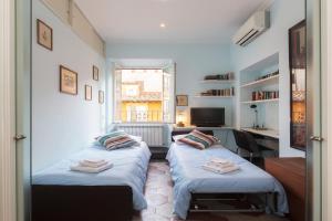 a bedroom with two beds and a desk and a window at Holidays Banchi Vecchi Apartment in Rome
