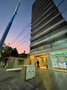 a man standing in front of a tall building at Dpto en av mate de luna a estrenar in Villa Luján