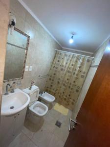 a bathroom with a sink and a toilet and a mirror at Dpto en av mate de luna a estrenar in Villa Luján