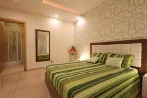 een slaapkamer met een groot bed en een groene deken bij Summer Breeze in Sliema +39 foto's