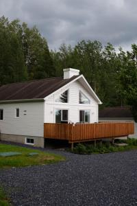 a large white house with a wooden deck at Chalet 3 OST Shefford in Shefford
