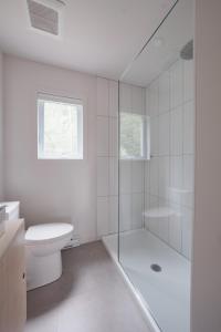 a white bathroom with a shower and a toilet at Chalet 1 OST Shefford in Shefford