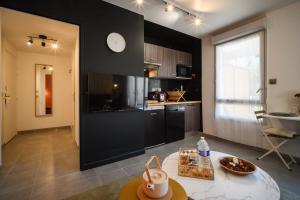 a kitchen with a table and a clock on the wall at Le Terra Rosa ~ Parking ~ Proche Airbus in Colomiers