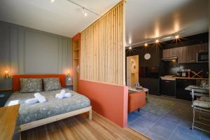 a bedroom with a bed and a kitchen at Le Terra Rosa ~ Parking ~ Proche Airbus in Colomiers