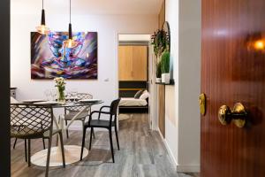 a dining room with a table and chairs and a painting at SingularStays Padre Urbano in Valencia
