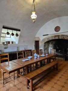 a dining room with a wooden table and a kitchen at Chateau de Presque in Saint-Médard-de-Presque