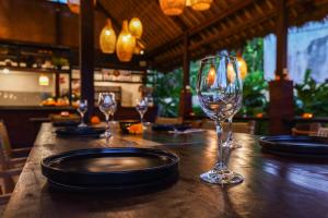 乌布Total Calm, 5 Minutes from Ubud!的酒吧的一张桌子和两杯酒杯