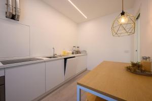 a kitchen with white cabinets and a wooden table at Appartamento Garibaldi in Morbegno