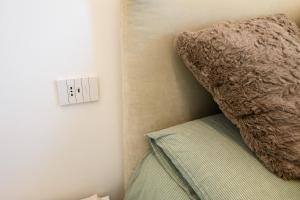 a bedroom with a light switch and a pillow at Appartamento Garibaldi in Morbegno +19 photos