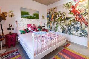 ein Schlafzimmer mit einem weißen Bett und einem Wandbild in der Unterkunft Tipsy Gipsy Horizon - More Wild than ever in Dambani