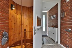 a bathroom with a wooden door and a brick wall at Ferienwohnung nahe A8 Augsburg München Ulm - Stillblick in Gersthofen +31 photos