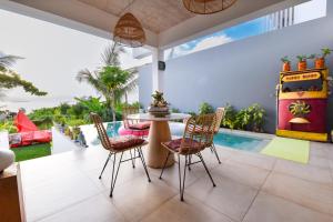ein Wohnzimmer mit einem Tisch, Stühlen und einem Pool in der Unterkunft Tipsy Gipsy Horizon - More Wild than ever in Dambani