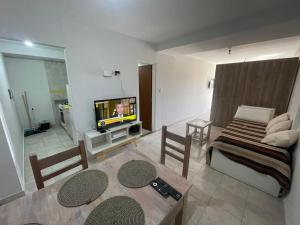 ein Wohnzimmer mit einer Couch und einem Tisch und einem Fernseher in der Unterkunft Dpto en av mate de luna, en el medio de la ciudad in Villa Luján