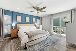 a bedroom with a bed and a ceiling fan at Beachside Vilano Lux Arcade Pets 6min to Historic in Vilano Beach