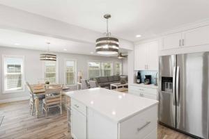 a kitchen and dining room with white cabinets and a table at Beachside Vilano Lux Arcade Pets 6min to Historic in Vilano Beach
