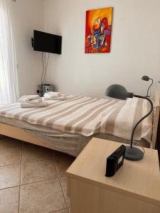 a bedroom with a bed and a desk with a lamp at Appartamento il Delfino - Beach House in Isola Rossa