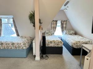 a room with two beds and a desk in it at The Boho - 4 min walk to beach & town in Bournemouth