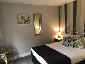 a small bedroom with a bed and a mirror at Duke Of Wellington in Matlock