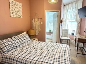 a bedroom with a bed and a desk and a window at The Boho - 4 min walk to beach & town in Bournemouth