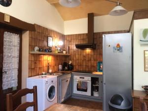 a kitchen with a refrigerator and a washing machine at Presbytère de cassagnes in Cassagnes +31 photos