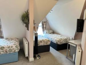 a small room with two beds and a window at The Boho - 4 min walk to beach & town in Bournemouth