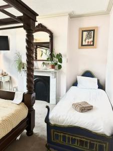 a bedroom with a bed and a fireplace at The Boho - 4 min walk to beach & town in Bournemouth