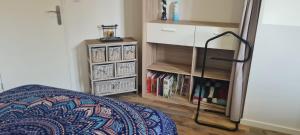 a bedroom with a bed and a book shelf at Maison de ressourcement au calme in Beuvry
