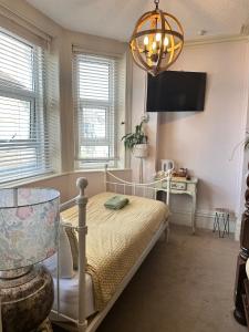 a bedroom with a bed and a tv and a lamp at The Boho - 4 min walk to beach & town in Bournemouth