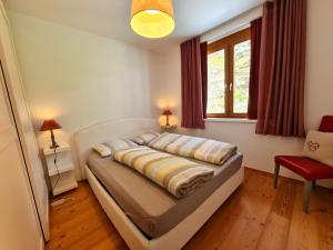 1 dormitorio con cama, silla roja y ventana en Haus Margaret By Globalimmoservice, en Bad Kleinkirchheim