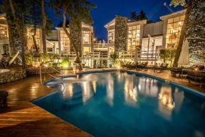 a swimming pool in front of a building at night at Runa Moraira Apart & Spa in Mar de las Pampas