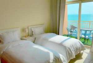 zwei Betten in einem Zimmer mit Meerblick in der Unterkunft لافيستا سي فيو ريزيدنس La Vista Sea View Residence family and business in King Abdullah Economic City + 71 Fotos