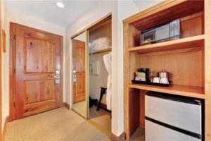 a room with a kitchen with a microwave and a door at Ski In, Ski Out Studio Condo In The Heart Of Lionshead Village With Hot Tub And Pool Access in Vail