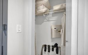 a white bathroom with a closet with a towel at Find Tranquility in the Grove in Miami +21 photos