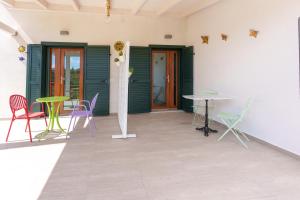 a patio with colorful chairs and tables in a room at Zì Rosa B&B in San Nicola Arcella