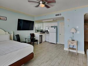 Un dormitorio con una cama y una cocina con una mesa. en Majestic Beach Towers I #312, en Panama City Beach