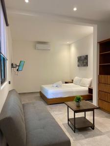 une chambre avec un lit, un canapé et une table dans l'établissement DOI 45 Apartment, à Playa del Carmen
