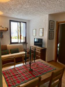 a living room with a table with green candles on it at La casa nel verde, un nido accogliente con vista in Folgarida