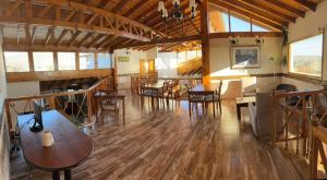 a large room with wooden floors and tables and chairs at Hotel Picos Del Sur in El Calafate +46 photos