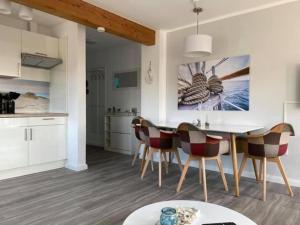 a kitchen and dining room with a table and chairs at Ferienwohnung Likedeeler in Dornumersiel