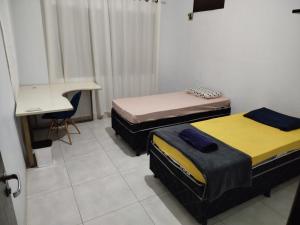 锡诺普Quarto individual com 2 camas box de solteiro hostel 940的客房设有三张床、一张桌子和一台电脑