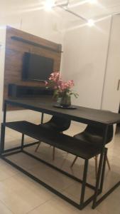 锡诺普Quarto individual com 2 camas box de solteiro hostel 940的一张黑色桌子,上面有花瓶