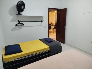 锡诺普Quarto individual com 2 camas box de solteiro hostel 940的卧室配有一张床,墙上配有风扇