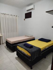 锡诺普Quarto individual com 2 camas box de solteiro hostel 940的一间配有电视的客房内配有两张床的房间