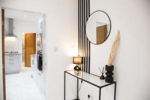 a hallway with a mirror and a glass table at Entire Luxury Home in Old Trafford, next to MUFC in Manchester