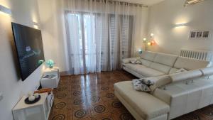 a living room with a white couch and a large window at La Residenza del Cavallino Affittacamere in Fermo